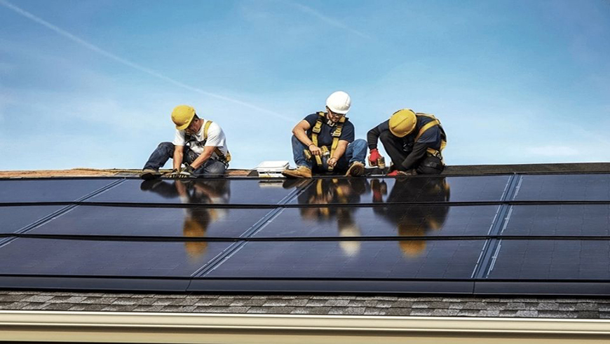 Roofers installing solar tiles