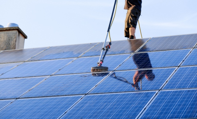 man cleaning solar panels