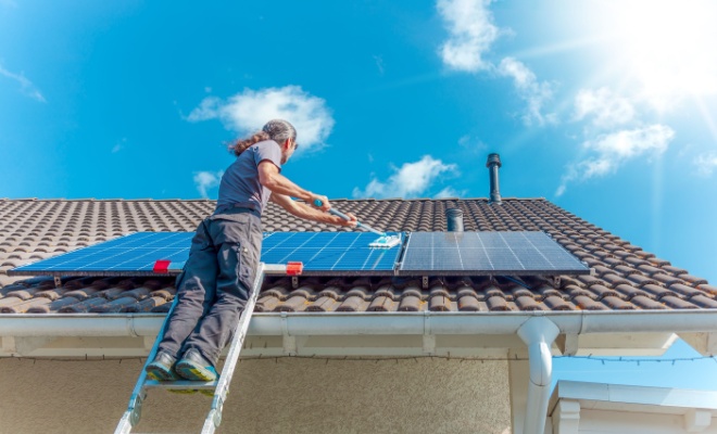 person cleaning solar panels