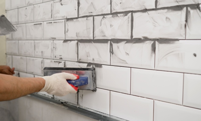 person grouting tiles